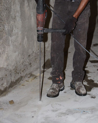Preparing to drill thru concrete floor with a 12 by 24 drill bit